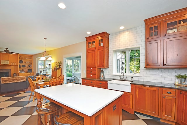 kitchen featuring a healthy amount of sunlight, sink, decorative backsplash, and a center island