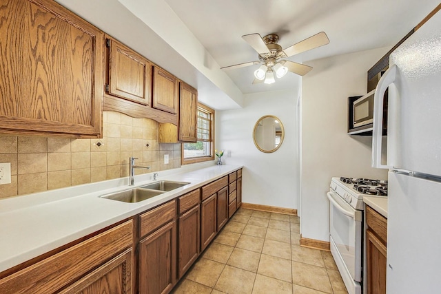 kitchen featuring decorative backsplash, light tile patterned flooring, white appliances, ceiling fan, and sink