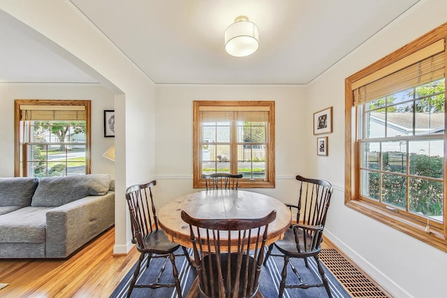 dining space featuring hardwood / wood-style floors and crown molding