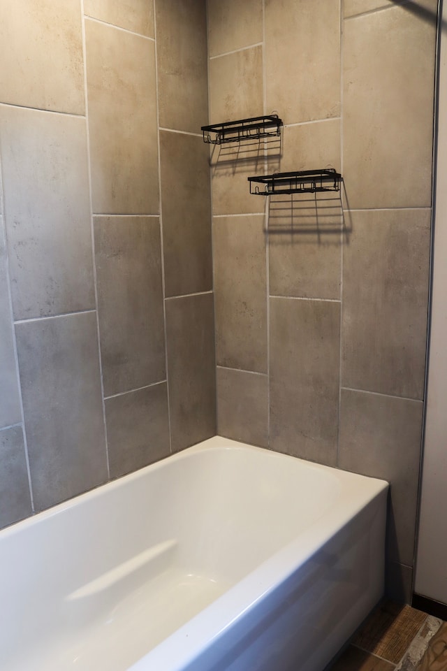 bathroom with wood-type flooring and a tub to relax in