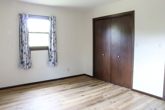 unfurnished bedroom featuring light hardwood / wood-style floors and a closet