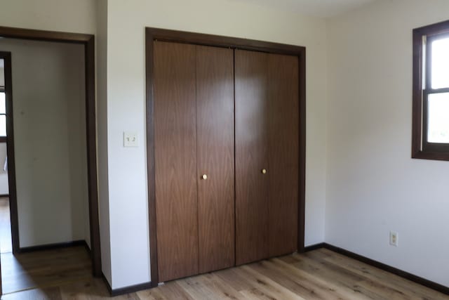 unfurnished bedroom featuring light wood-type flooring and a closet