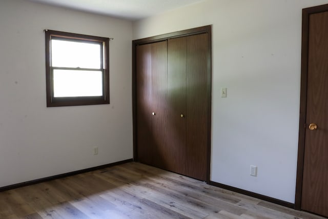 unfurnished bedroom with a closet and light hardwood / wood-style floors