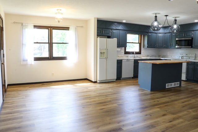 kitchen with wood-type flooring, white appliances, and a center island