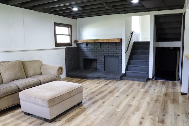 living room featuring light hardwood / wood-style floors and a brick fireplace