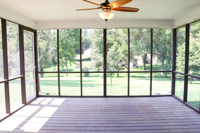 unfurnished sunroom featuring ceiling fan and plenty of natural light