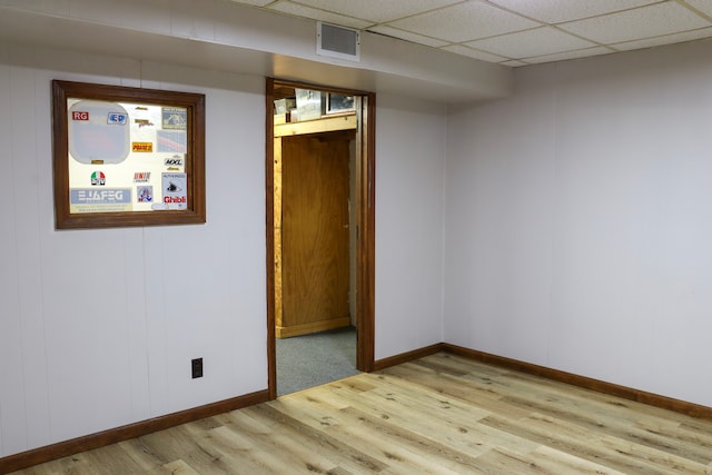 unfurnished room featuring light wood-type flooring and a drop ceiling