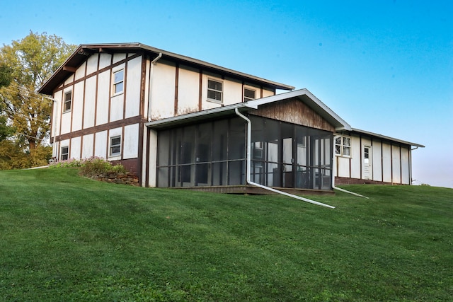 back of property with a sunroom and a yard