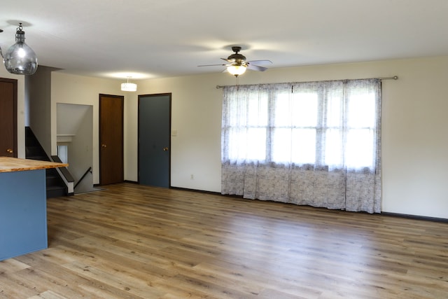 unfurnished living room featuring ceiling fan and hardwood / wood-style flooring