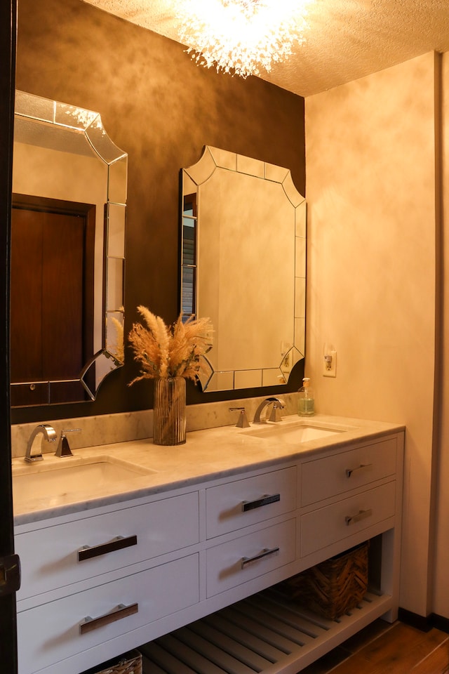 bathroom with hardwood / wood-style floors, a textured ceiling, and vanity