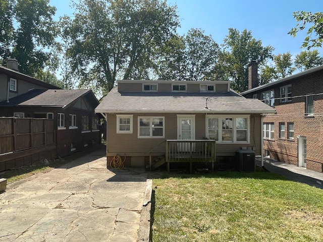 back of property featuring a lawn and central AC unit