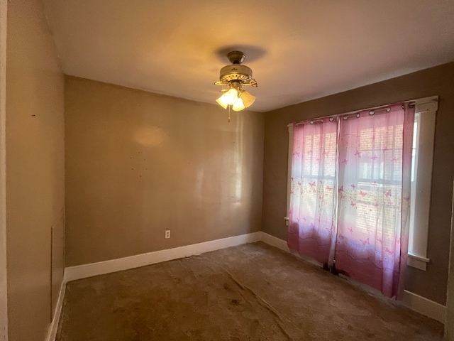 unfurnished room with ceiling fan and carpet