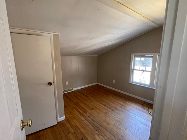 additional living space with wood-type flooring and lofted ceiling