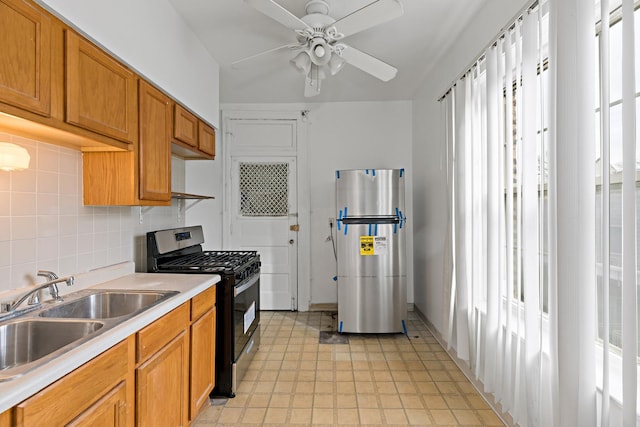 kitchen featuring stainless steel appliances, a sink, a ceiling fan, light countertops, and backsplash