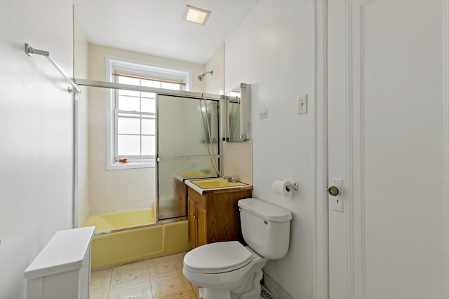 bathroom with combined bath / shower with glass door, a sink, and toilet