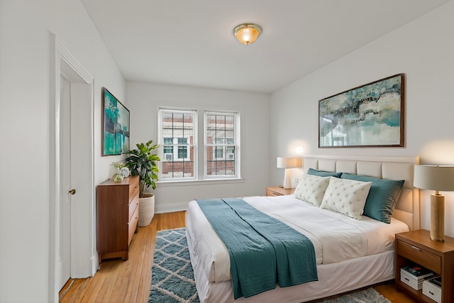 bedroom with light wood-style flooring and baseboards