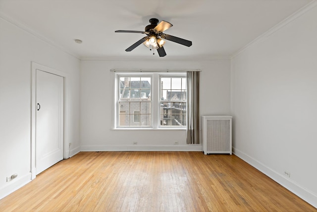 unfurnished room featuring light wood-style floors, radiator heating unit, baseboards, and crown molding