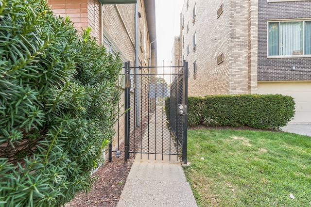 view of gate featuring a lawn and a garage