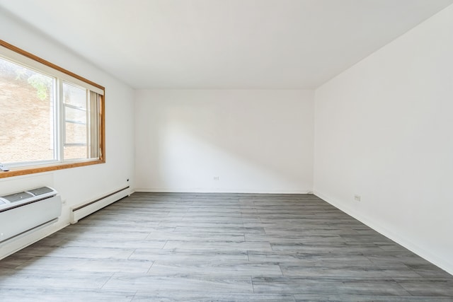 unfurnished room featuring light wood-type flooring and baseboard heating