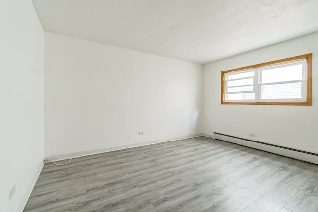 spare room featuring light hardwood / wood-style floors and baseboard heating