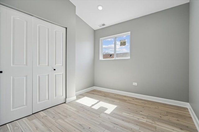 unfurnished bedroom with light wood-type flooring and a closet