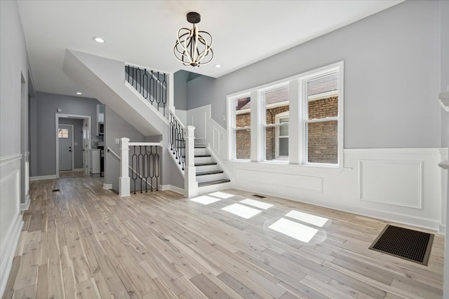 foyer entrance featuring an inviting chandelier and light hardwood / wood-style floors