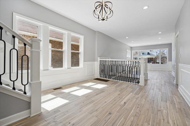 interior space with an inviting chandelier and light hardwood / wood-style flooring