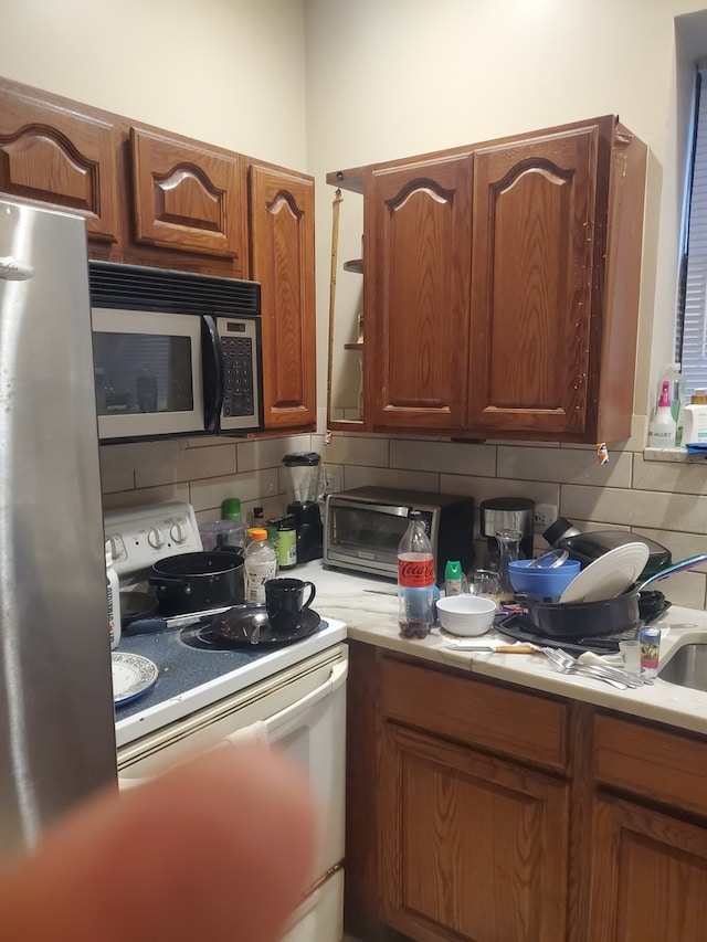 kitchen with appliances with stainless steel finishes and tasteful backsplash