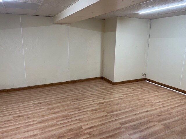 basement featuring light hardwood / wood-style floors and a paneled ceiling