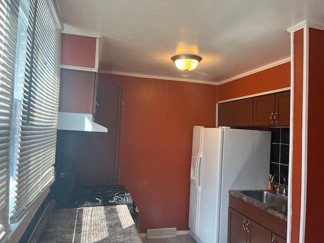 kitchen with ornamental molding, sink, decorative backsplash, and white refrigerator with ice dispenser