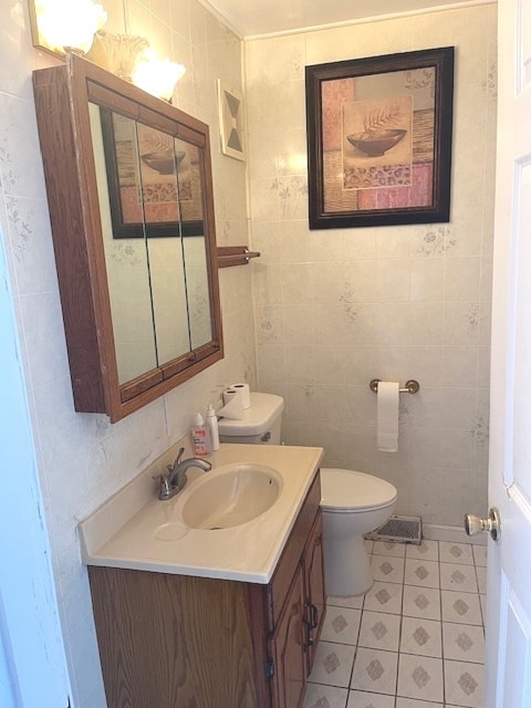 bathroom featuring vanity, toilet, tile walls, and tile patterned flooring