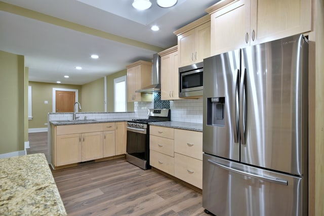 kitchen featuring wall chimney range hood, stainless steel appliances, dark hardwood / wood-style flooring, and sink