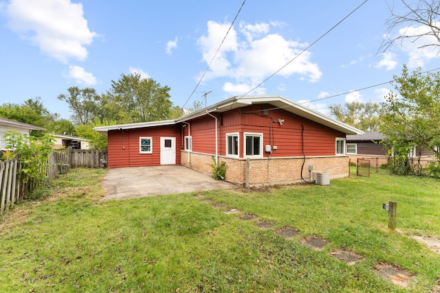 rear view of house with a patio, a yard, and central air condition unit