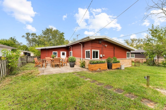 rear view of property with a yard and a patio area