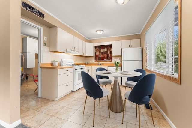 kitchen featuring white cabinetry, tasteful backsplash, white appliances, crown molding, and range hood