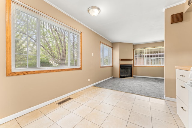 unfurnished living room with light tile patterned flooring and crown molding