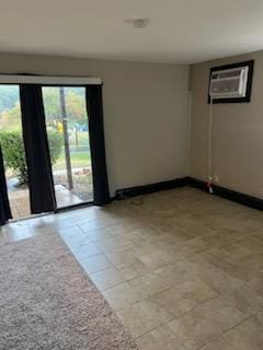 empty room with light tile patterned floors and a wall mounted air conditioner