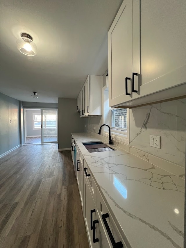 kitchen featuring dark hardwood / wood-style floors, sink, light stone counters, and white cabinets