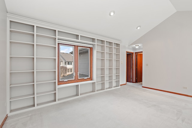 carpeted empty room featuring vaulted ceiling