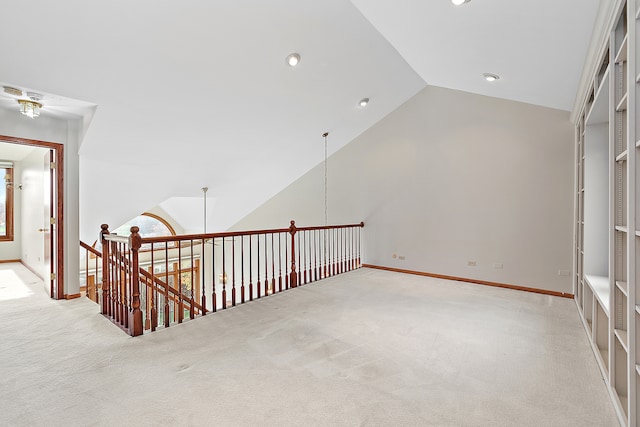 unfurnished room with light carpet and vaulted ceiling