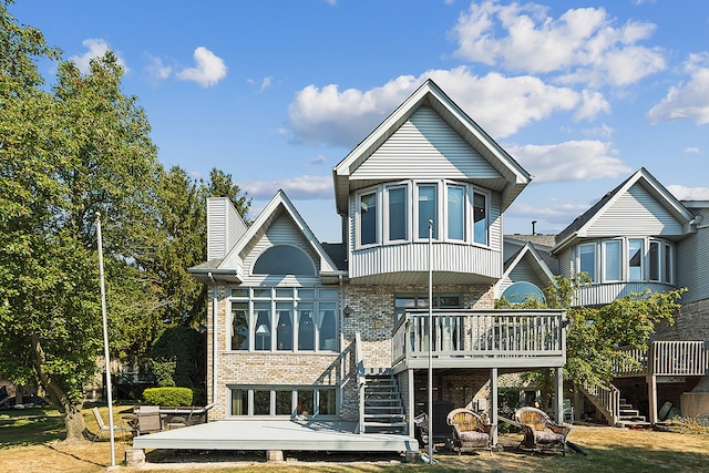 back of property featuring a lawn and a deck