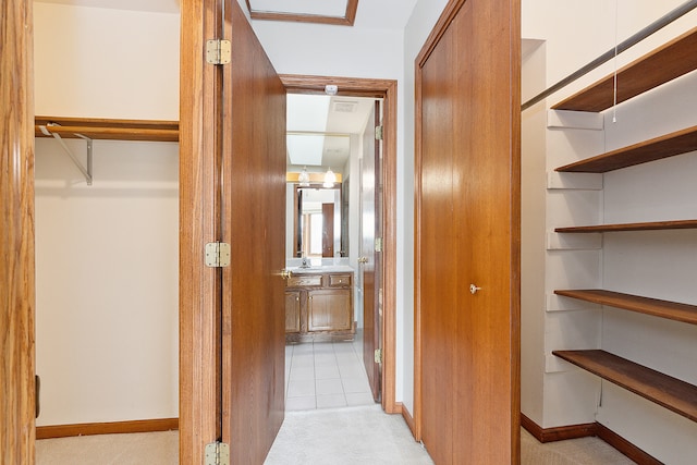 hall with light tile patterned floors and sink