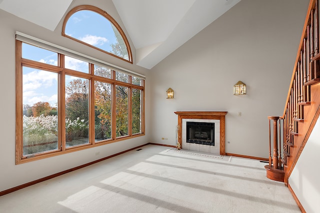 unfurnished living room with a wealth of natural light, a fireplace, and high vaulted ceiling