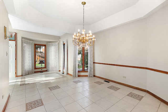 unfurnished dining area featuring light tile patterned floors, a tray ceiling, and an inviting chandelier