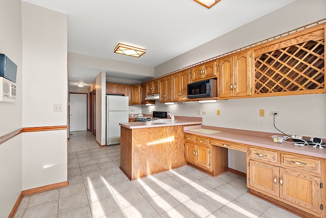 kitchen featuring light tile patterned floors, built in desk, stainless steel range, white fridge, and kitchen peninsula