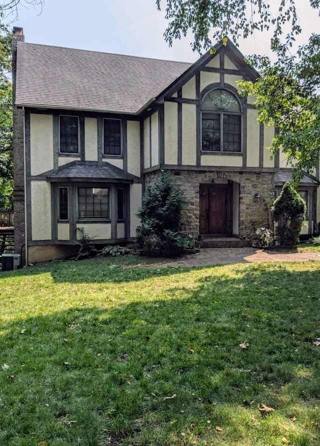 tudor-style house with a front yard