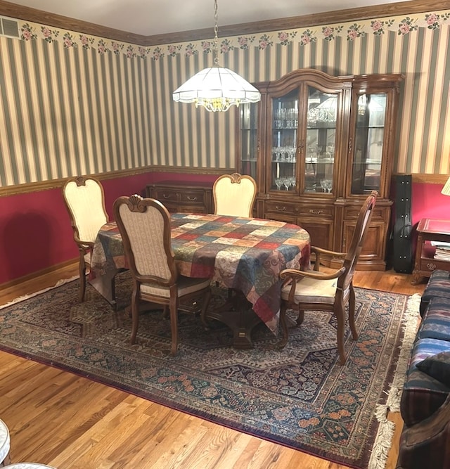 dining room with ornamental molding and hardwood / wood-style floors