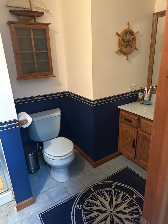 bathroom with tile patterned flooring, vanity, and toilet