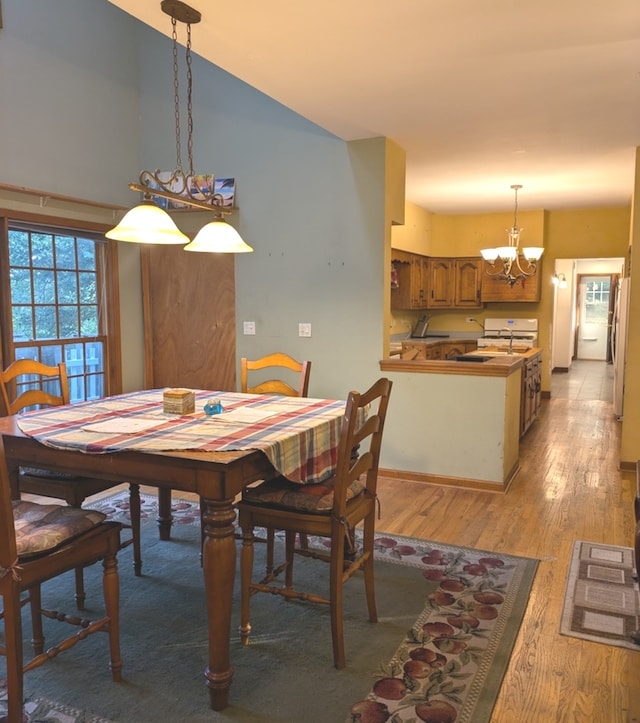 dining space featuring light hardwood / wood-style floors and a chandelier