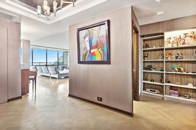 corridor featuring a notable chandelier and light parquet floors